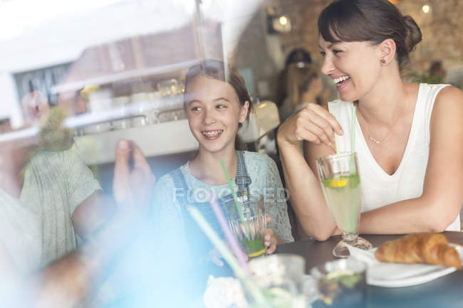 Family laughing at cafe table — Stock Photo