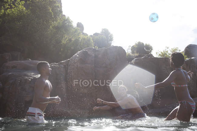Friends playing soccer in river — Stock Photo
