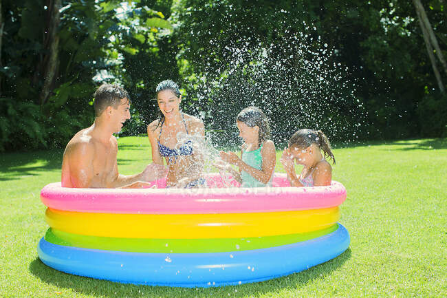 Family playing together in wading pool — Stock Photo