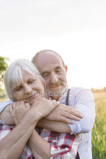 Nahaufnahme Porträt heiteres Seniorenpaar, das sich mit geschlossenen Augen umarmt — Stockfoto