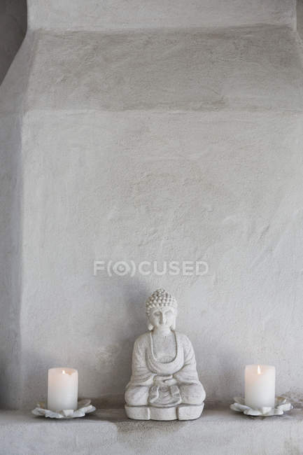 Buddha-Figur und Kerzen auf Sims, Nahaufnahme — Stockfoto