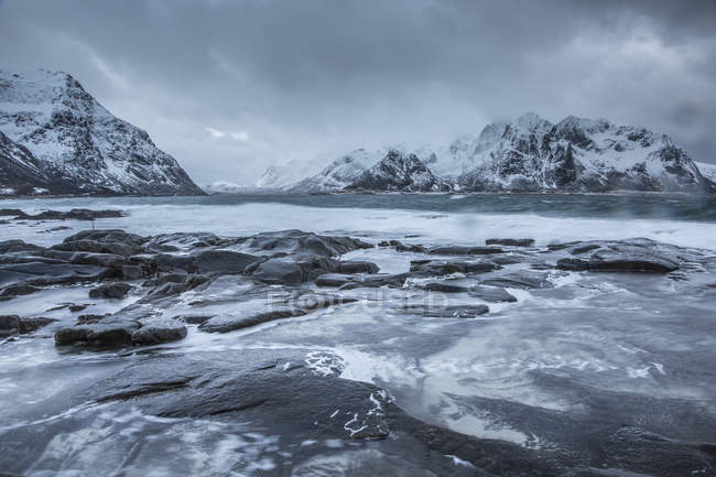 Schneebedeckte Berge hinter kaltem Meer, Vareid, erhabene Inseln, Norwegen — Stockfoto