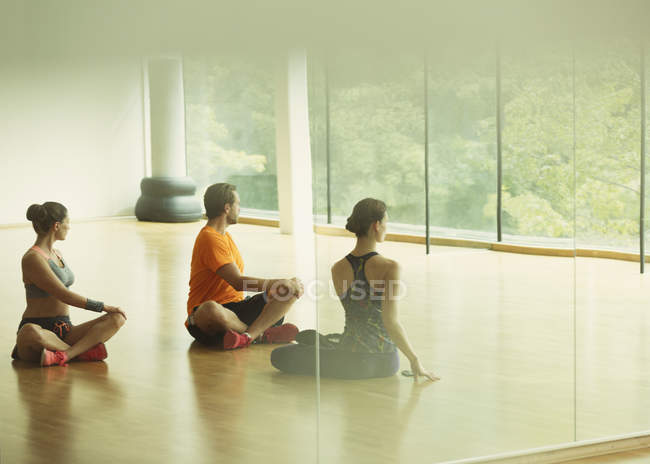 Man and women doing twisted stretch in gym studio — Stock Photo