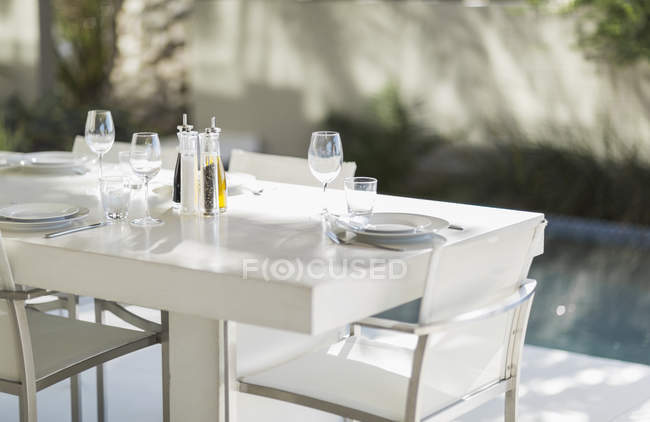 Gedeckter Esstisch auf moderner Terrasse am Pool — Stockfoto