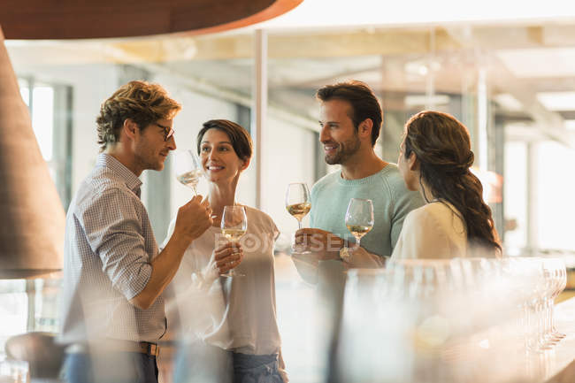 Friends wine tasting white wine in winery tasting room — Stock Photo
