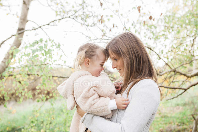 Zärtliche Mutter hält Kleinkind-Tochter im Park — Stockfoto
