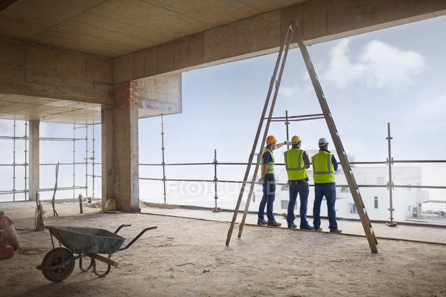 Trabajadores de la construcción en obra de gran altura - foto de stock