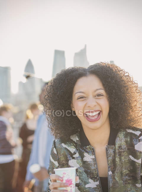 Портрет сміється молода жінка п'є на вечірці — стокове фото