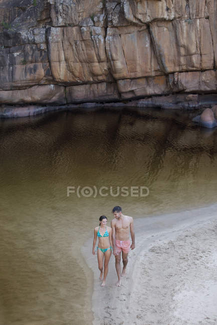 Couple marchant le long de la piscine — Photo de stock