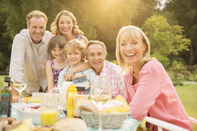 Семья из нескольких поколений за столом на заднем дворе — стоковое фото