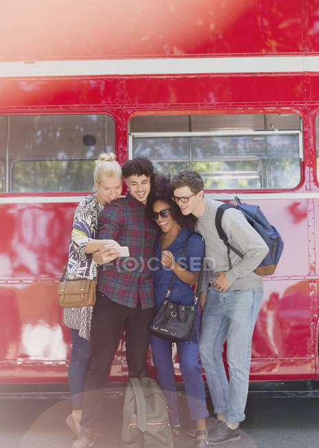 Amigos tomando selfie al lado del autobús de dos pisos - foto de stock