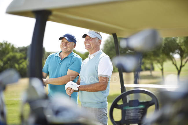 Senior men standing next to golf cart — Stock Photo