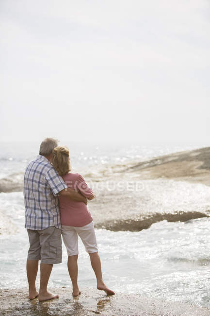 Взрослая пара, обнимающаяся на пляже — стоковое фото
