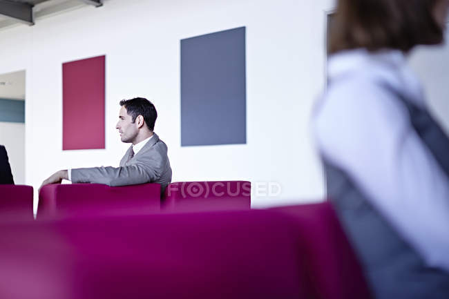 Empresário adulto bem sucedido sentado no lobby — Fotografia de Stock
