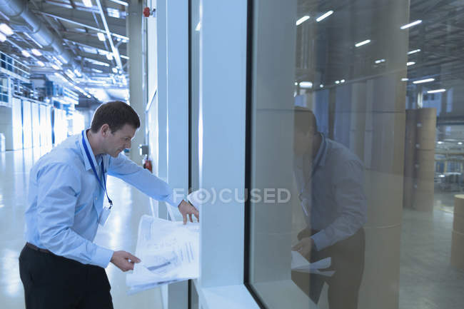 Engineer reviewing blueprints in factory — Stock Photo