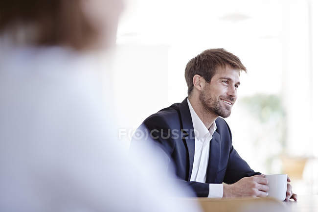 Businessman drinking cup of coffee in cafe — Stock Photo