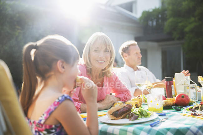 Heureuse famille manger le déjeuner à la table de patio — Photo de stock
