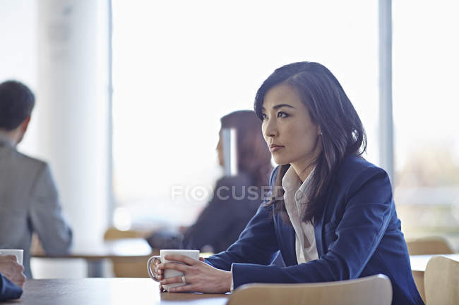 Erfolgreiche erwachsene Geschäftsfrau trinkt Kaffee im Café — Stockfoto