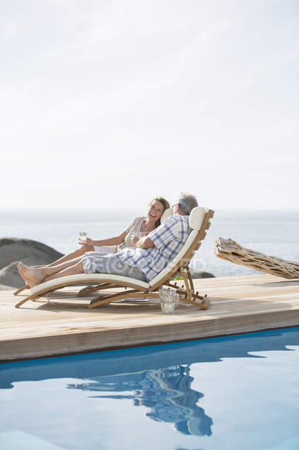 Пара пожилых людей отдыхает у бассейна — стоковое фото