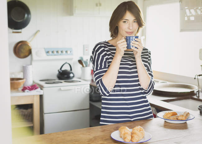 Bruna donna bere caffè in cucina — Foto stock