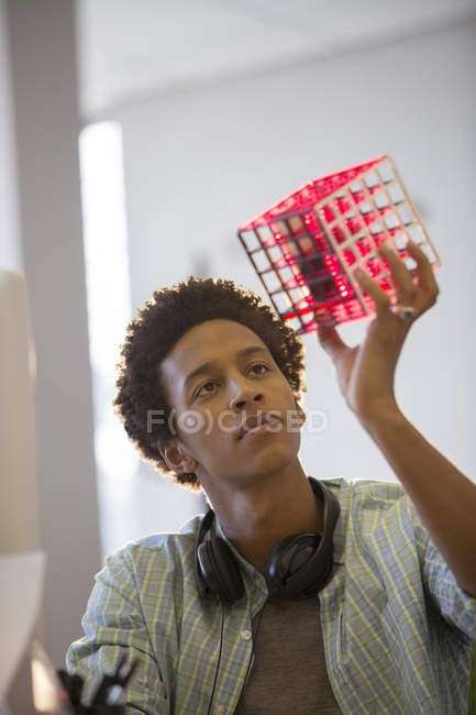 Businessman examining cube in modern office — Stock Photo