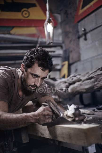 Blacksmith chiseling wood in forge — Stock Photo