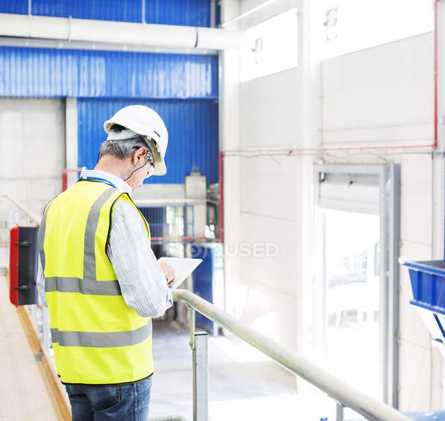 Worker with digital tablet in warehouse — Stock Photo