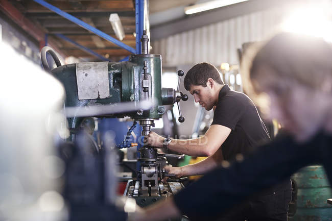 Mecânica que utiliza máquinas na oficina de reparação de automóveis — Fotografia de Stock