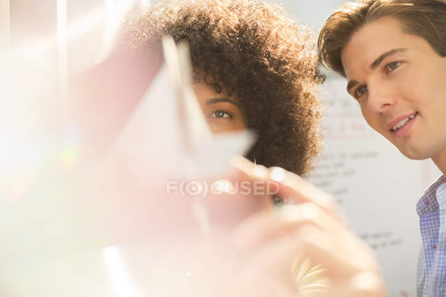 Business people looking at model in modern office — Stock Photo