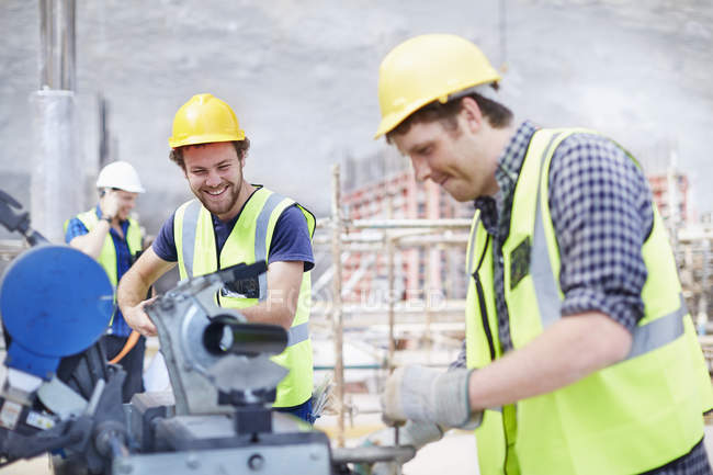 Travailleurs de la construction utilisant des équipements sur le chantier — Photo de stock