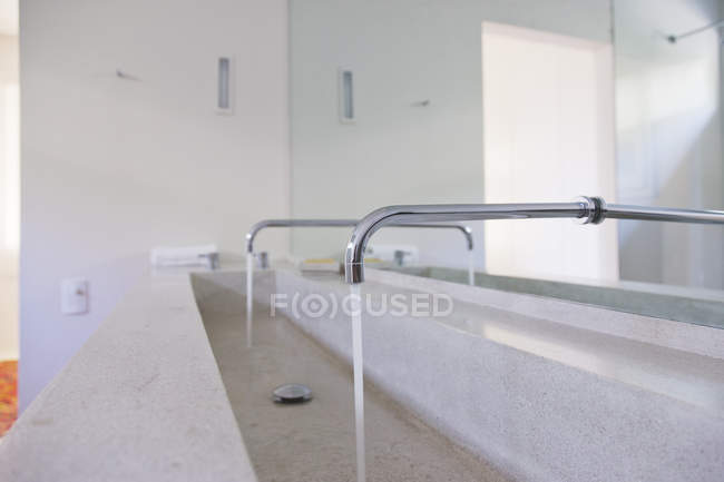 Running faucets in modern bathroom — Stock Photo