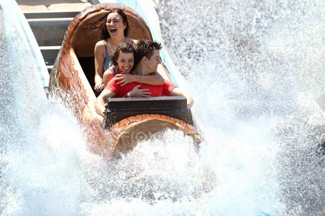 Des amis enthousiastes se font éclabousser dans un parc d'attractions en rondins d'eau — Photo de stock