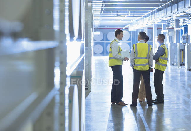 Trabajadores hablando en corredor de fábrica - foto de stock