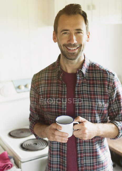 Portrait souriant brunette homme buvant du café dans la cuisine — Photo de stock