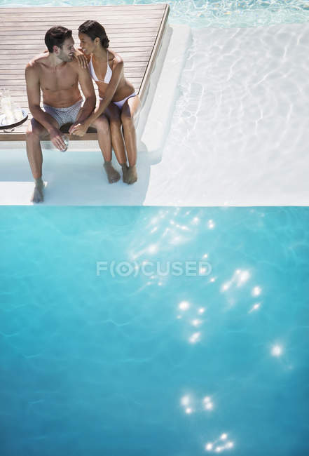 Giovane coppia rilassante insieme a bordo piscina — Foto stock