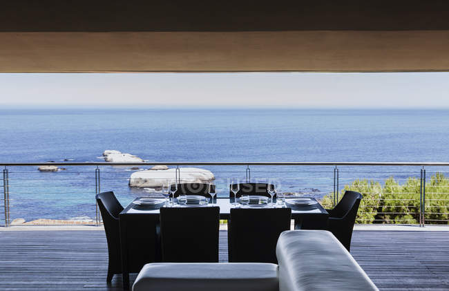 Mesa de comedor en balcón de lujo con vistas al océano - foto de stock