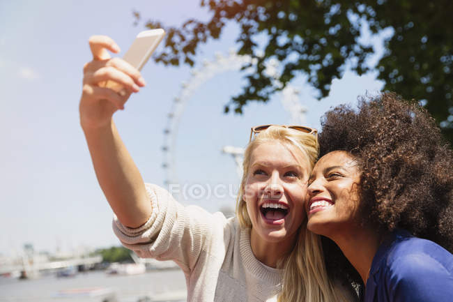 Amis prenant selfie avec London Eye en arrière-plan, Londres, Royaume-Uni — Photo de stock