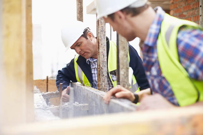 Trabajadores de la construcción examinando estructura en obra - foto de stock
