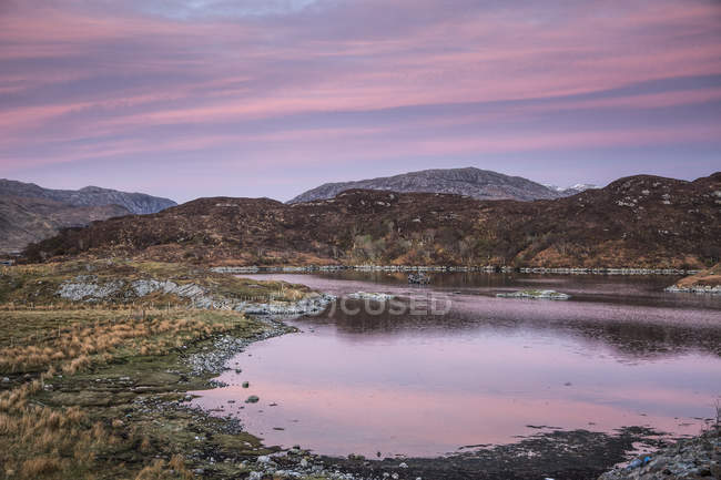 Cielo rosado del amanecer sobre Badcall Bay, Sutherland, Escocia - foto de stock