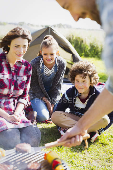 Family barbecuing at sunny campsite — Stock Photo