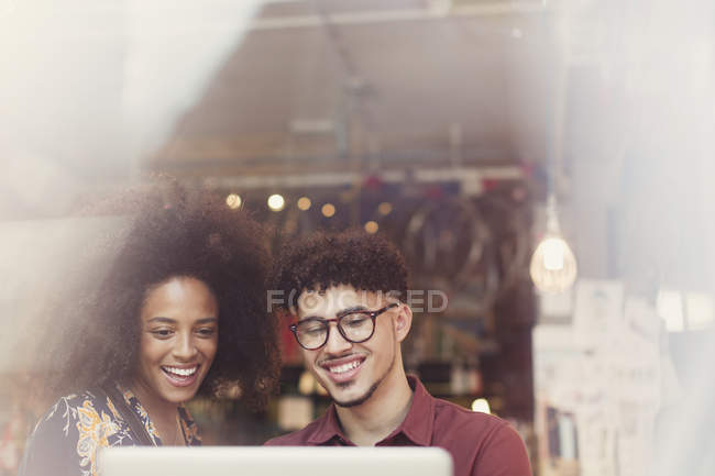 Couple using laptop in cafe window — Stock Photo