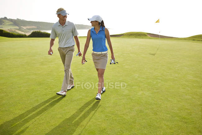 Couple caucasien marche sur le terrain de golf — Photo de stock