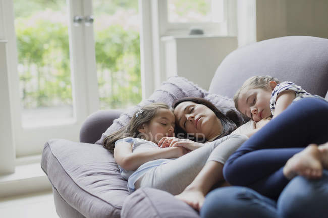 Serena mãe e filhas cochilando no sofá da sala — Fotografia de Stock