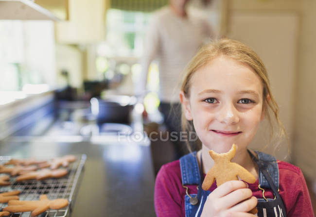 Portrait smiling girl eating gingerbread cookie — Stock Photo