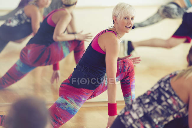 Fitness instructor leading class in lunge — Stock Photo