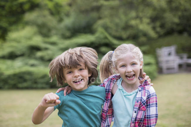 Щасливі усміхнені діти обіймаються на відкритому повітрі — стокове фото