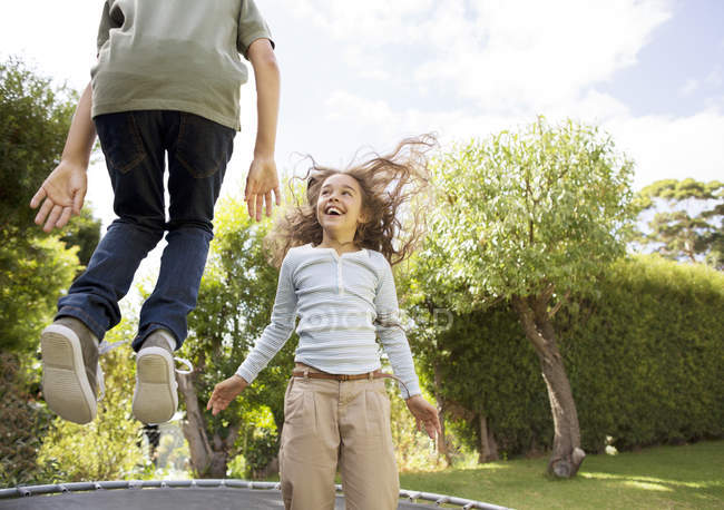 Дети прыгают на батуте на заднем дворе — стоковое фото