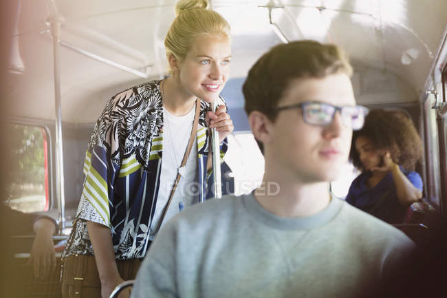 Улыбающаяся женщина смотрит в окно автобуса — стоковое фото