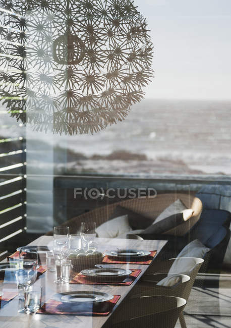Накрыть стол в современной столовой с видом на океан — стоковое фото