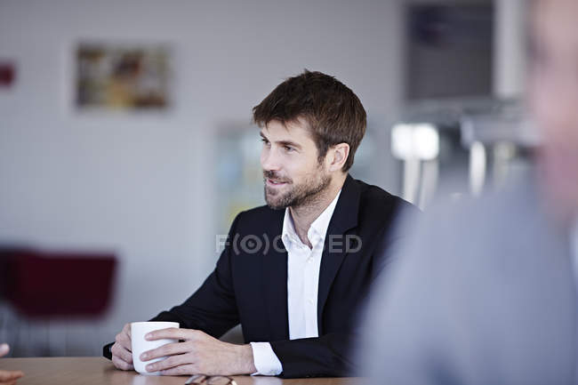 Успешный взрослый бизнесмен пьет кофе в кафе — стоковое фото